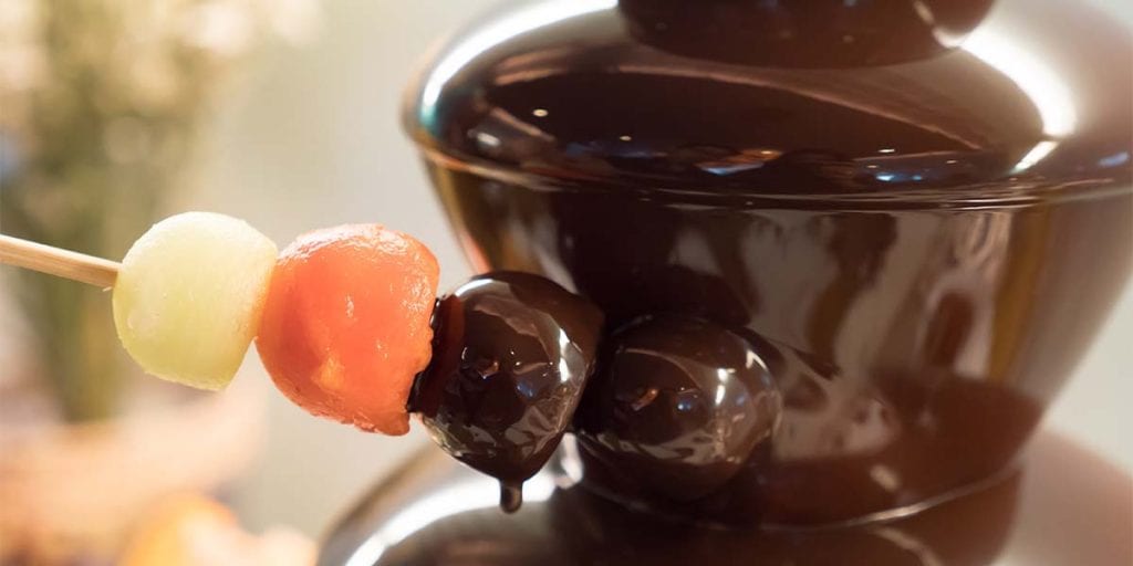 Deja hueco en una mesa para colocar una fuente o una fondue de chocolate fundido, donde cada uno pueda elegir lo que quiere bañar dentro.